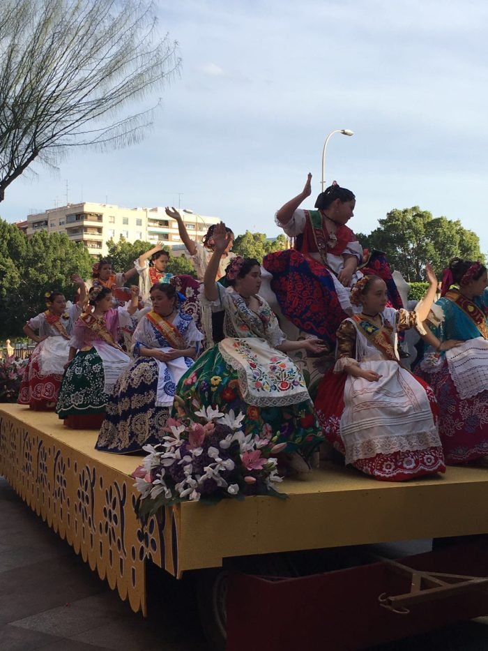 Young women in traditional huertana dress on a float at the Bando de la Huerta, Murcia