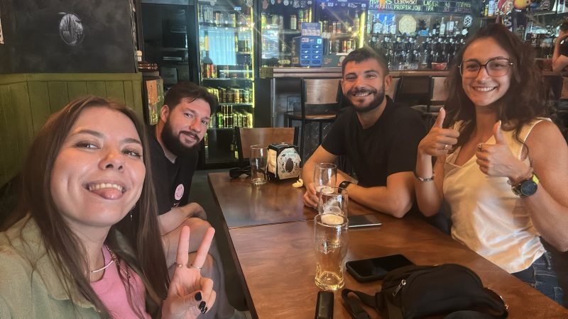 Héctor with students at a bar, thumbs up